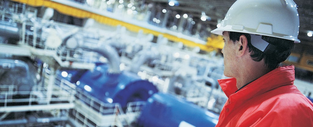 Engineer wearing hard hat overlooking the interior of a Nuclear power station