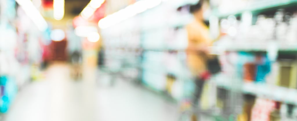 Blurred photo of a person shopping in a supermarket aisle