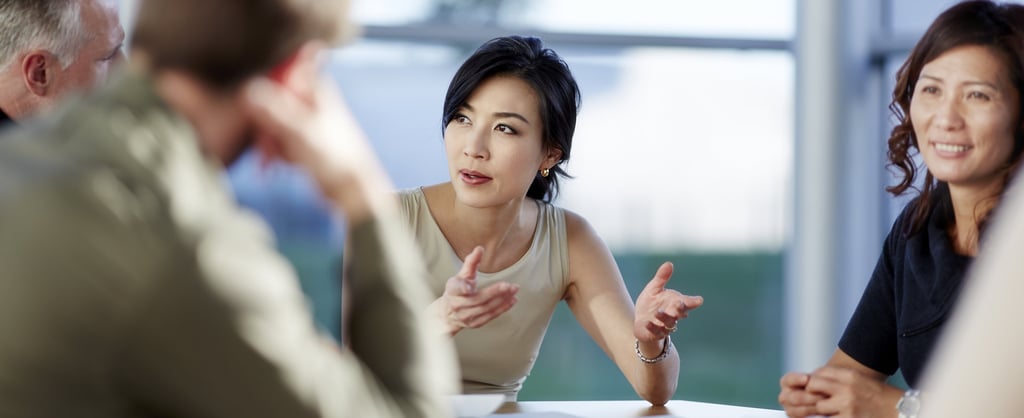 Image of a person sitting down talking to other people