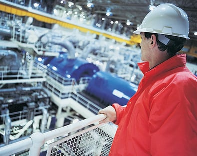 Engineer wearing hard hat overlooking the interior of a Nuclear power station