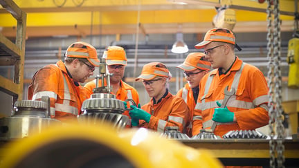 Engineer teaching apprentices in factory