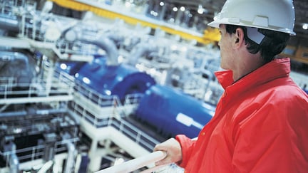 Engineer wearing hard hat overlooking the interior of a Nuclear power station