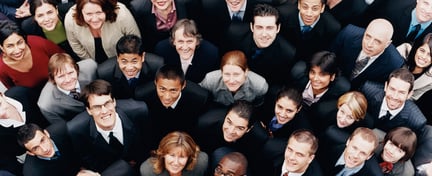 Large group of business people standing and looking up at camera