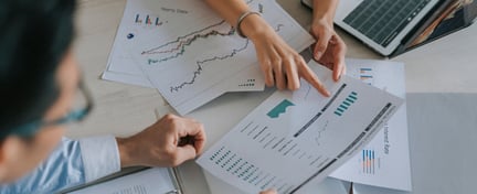 Image of two people sitting down looking through a business report