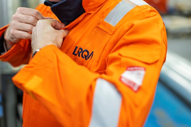 Closeup of a person wearing an LRQA high-visibility jacket